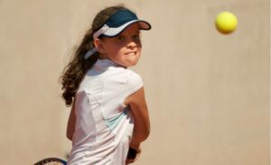 テニスに励む女子ジュニアテニスプレーヤー