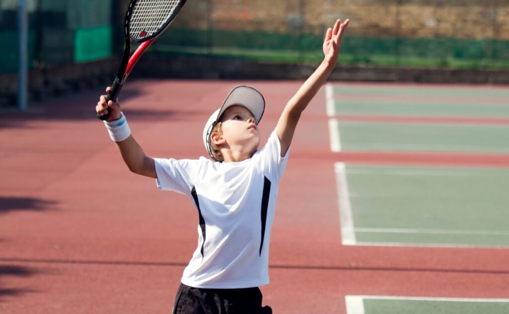 サーブを打つジュニアテニスプレーヤー