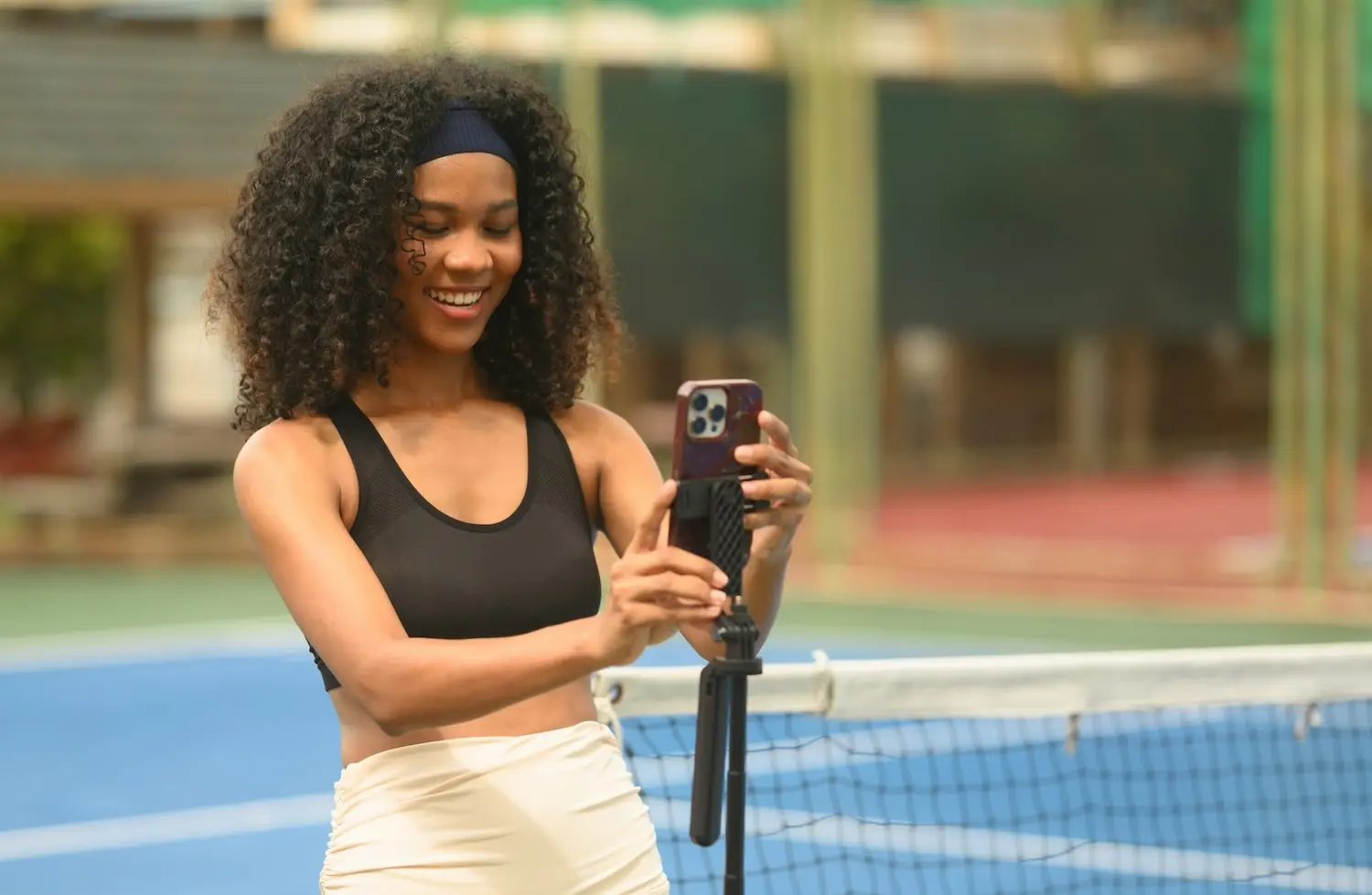 スマートフォンで動画を撮るテニス選手